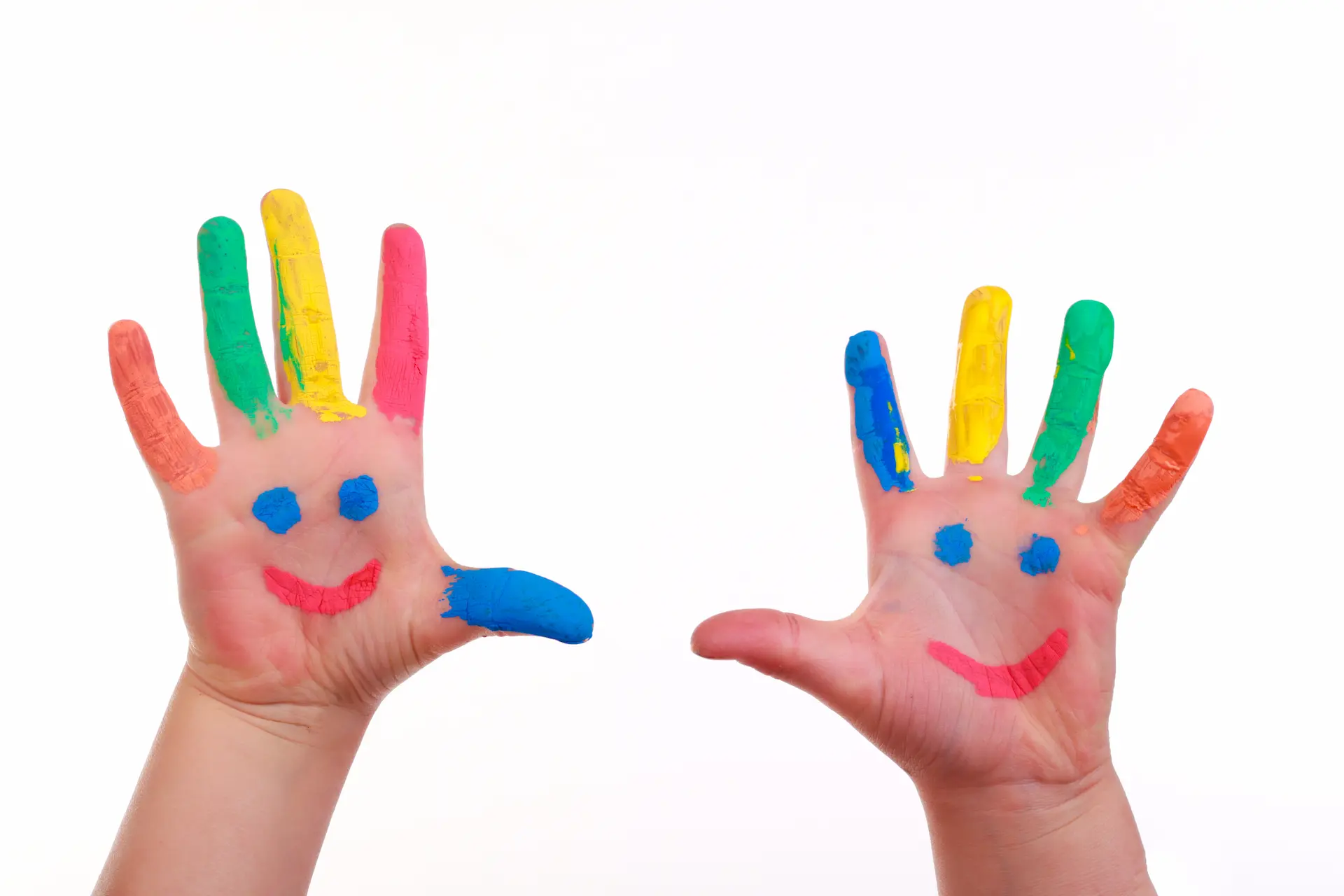 Das Bild zeigt eine Hand mit bemalten Fingern. Die Hand scheint einem Kind zu gehören, und das Gemälde könnte eine Form von Kinderkunst sein. Die Finger sind mit verschiedenen Farben bemalt, und im Hintergrund ist ein Spielzeug zu sehen.